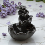 Triple Lily Leaf Backflow Incense Burner with purple flowers on a marble surface