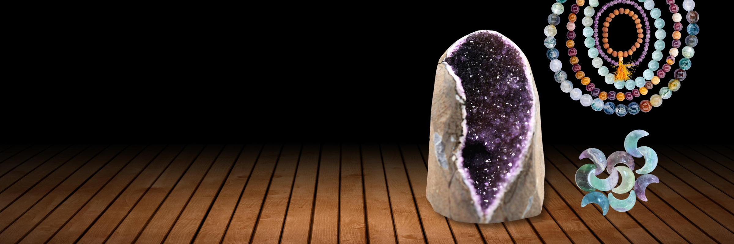 Amethyst crystal and crystal bracelets on a wooden surface with a dark background