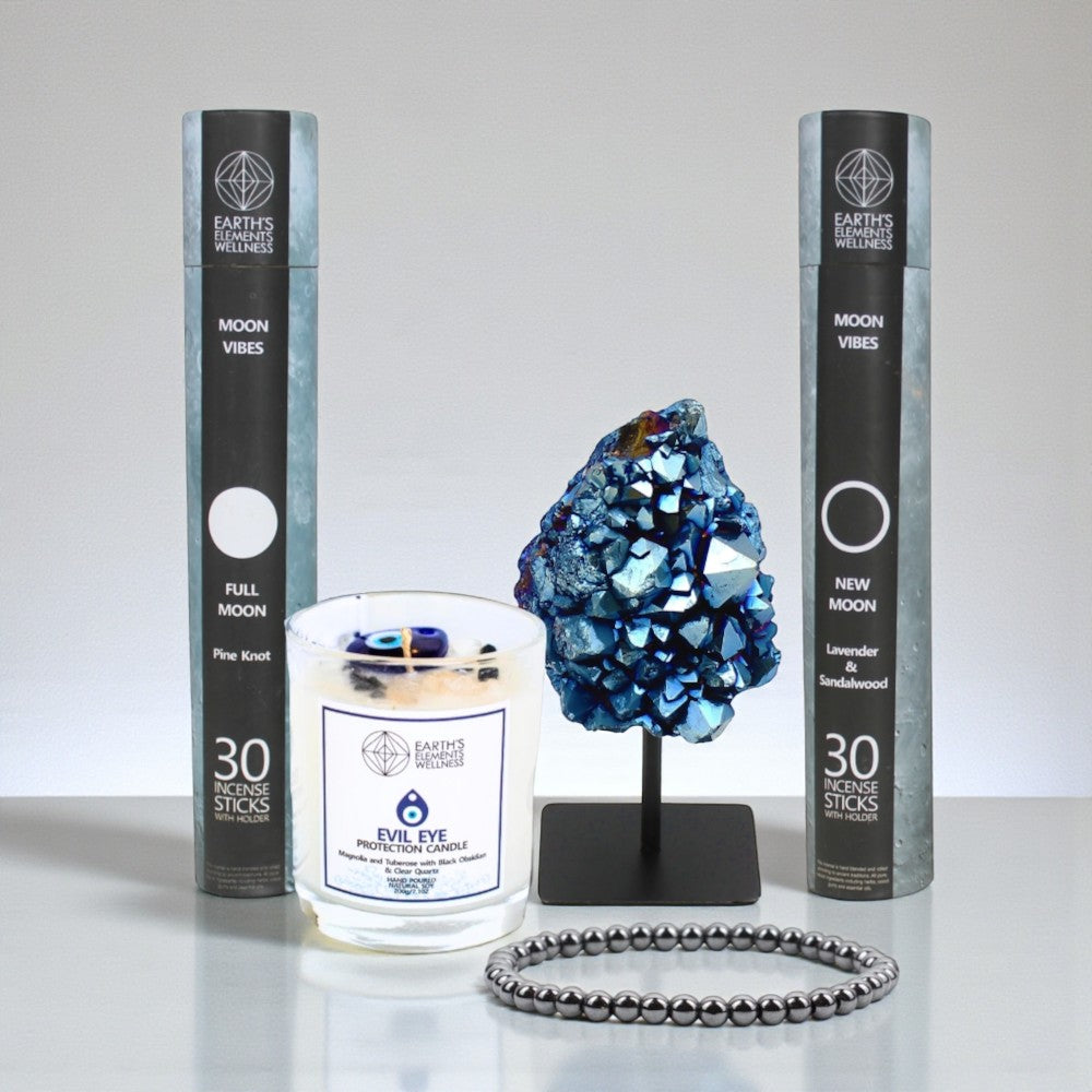Candle, crystal, incense and bracelet on a white surface with a gray background