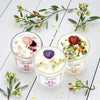 Three crystal candles on a white wooden surface with floral decorations.