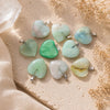 Fluorite Mini Heart Pendants on a warm limestone surface with soft linen and dried florals in natural sunlight.