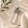 Clear Quartz Point Pendant with Turquoise featuring a faceted clear quartz crystal, ornate silver cap, and turquoise accent.