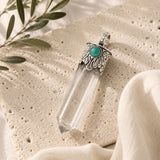 Clear Quartz Point Pendant with Turquoise featuring a faceted clear quartz crystal, ornate silver cap, and turquoise accent.