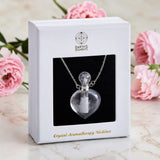 Crystal aromatherapy necklace in a white box with pink flowers in the background