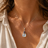 Opalite and amethyst sterling silver pendant worn on a silver chain.