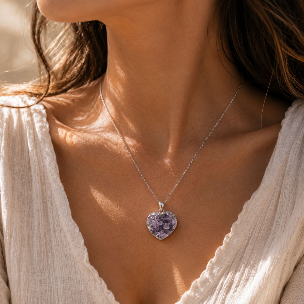Close-up of a woman wearing a necklace with a heart-shaped purple pendant.