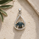 Raw Blue Apatite silver teardrop pendant displayed on a natural stone surface with soft daylight. Each pendant features a unique raw blue apatite crystal in a polished silver teardrop setting.