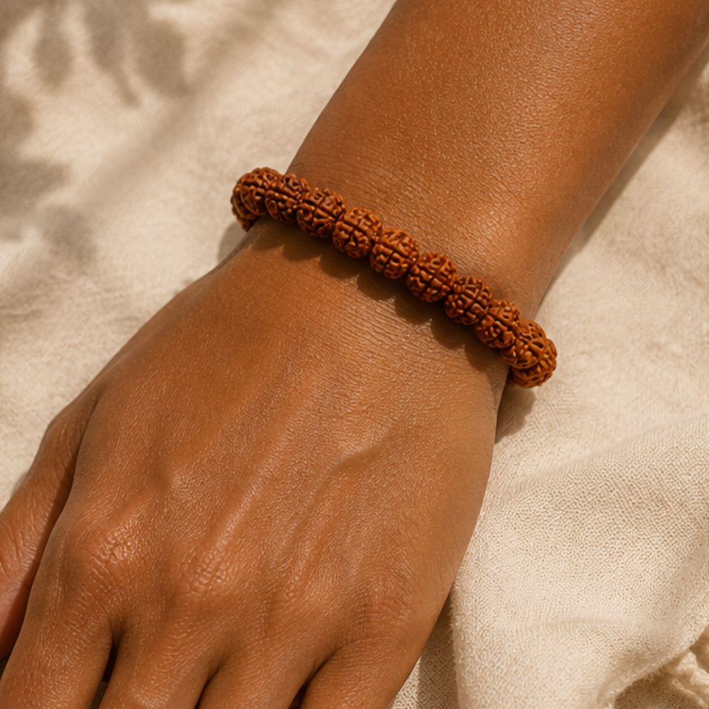 Brown beaded bracelet on a wrist with a neutral background
