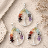 Three Tree of Life pendants featuring silver wire trees with colorful natural gemstone chips on a textured stone background.