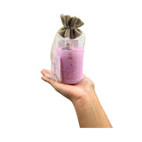 Hand holding a Libracandle in a drawstring bag on a white background