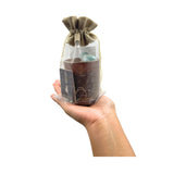 Hand holding a packaged product with a decorative bow on a white background
