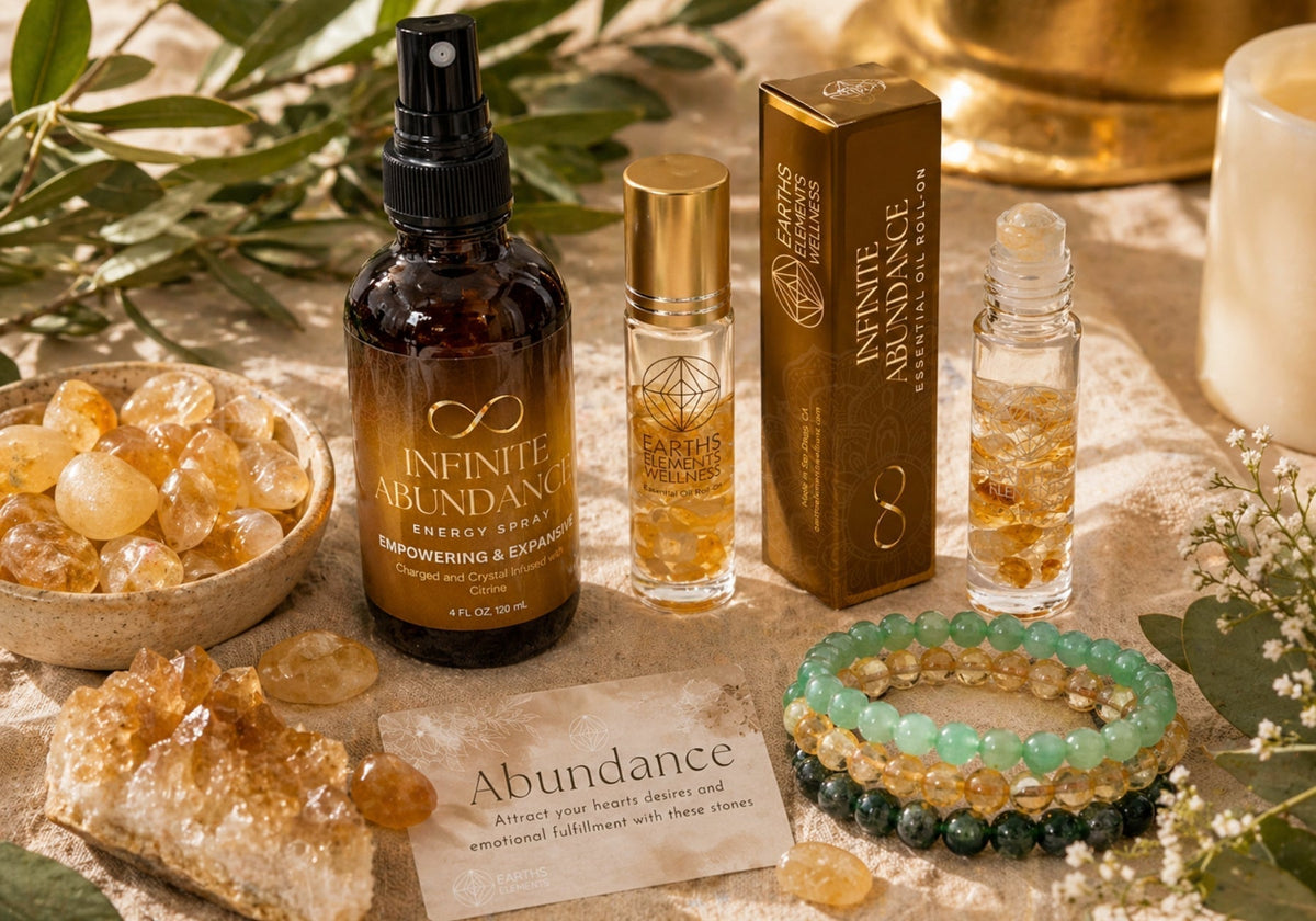Infinite Abundance spray, roll-ons, bracelets, and citrine crystals displayed on linen.