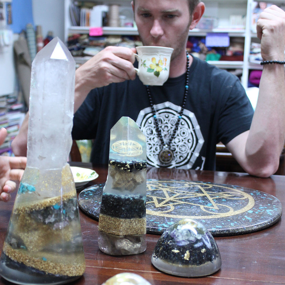 you man drinking form a cup with crystals in front of him on the table