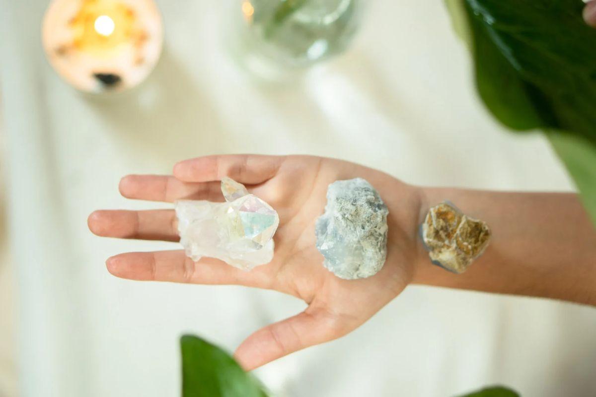 hand holding a 3 pieces of raw crystals