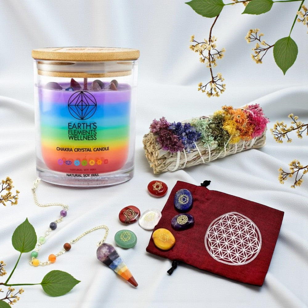 Chakra candle with crystals, stones, and a pouch on a white fabric background