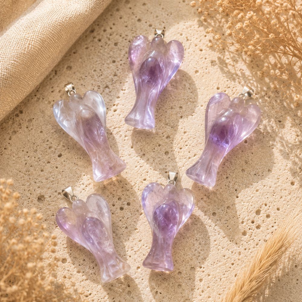 Amethyst angel crystal pendants on a neutral textured background.