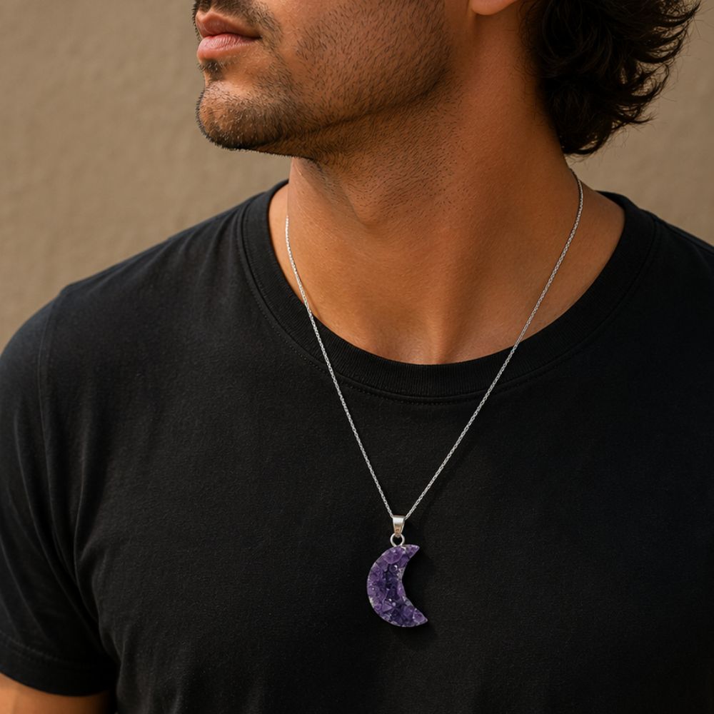 Man wearing a black t-shirt with a silver necklace featuring a purple crescent moon pendant.