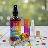 Chakra alignment products including a spray , roll-on and chakra sage on a wooden surface with a blurred natural background.