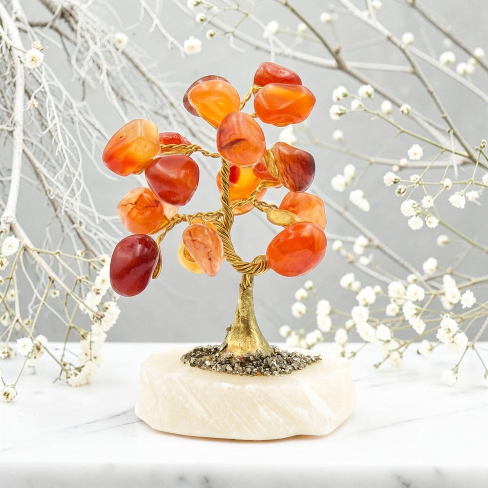 Decorative tree sculpture with orange and red stones on a marble base, against a neutral background.