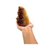 Hand holding a large citrine with brown and beige colors on a white background