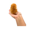 Hand holding a large citrine rock against a white background