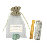 Cleansing bundle with sage, Palo Santo, and crystal in a drawstring bag on a white background