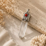 Clear Quartz Point Pendant with Coral featuring a faceted clear quartz crystal, ornate silver cap, and red coral accent.