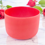 Red bowl on a marble surface with red roses in the background