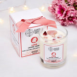 Crystal candle with packaging and flowers on a white background