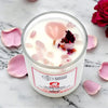 Candle with pink petals and dried flowers on a marble surface, featuring the brand 'Earth's Elements'.
