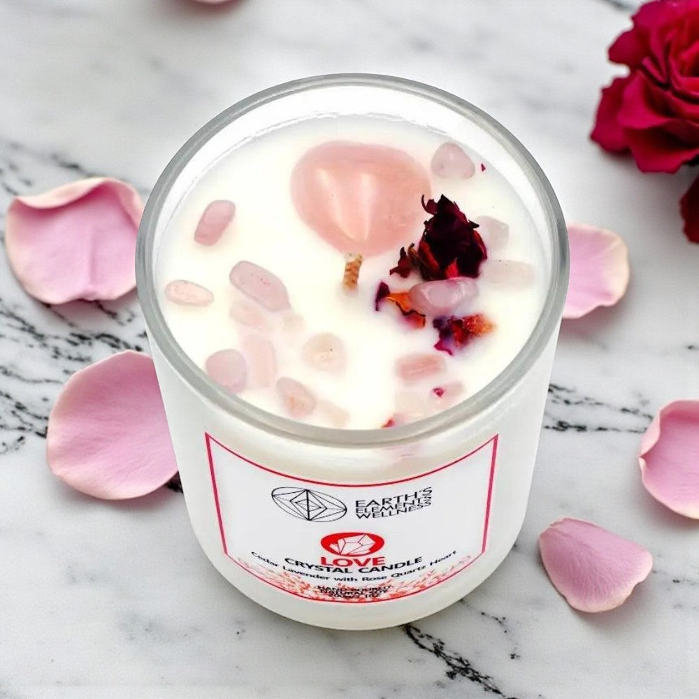 Candle with pink petals and dried flowers on a marble surface, featuring the brand 'Earth's Elements'.
