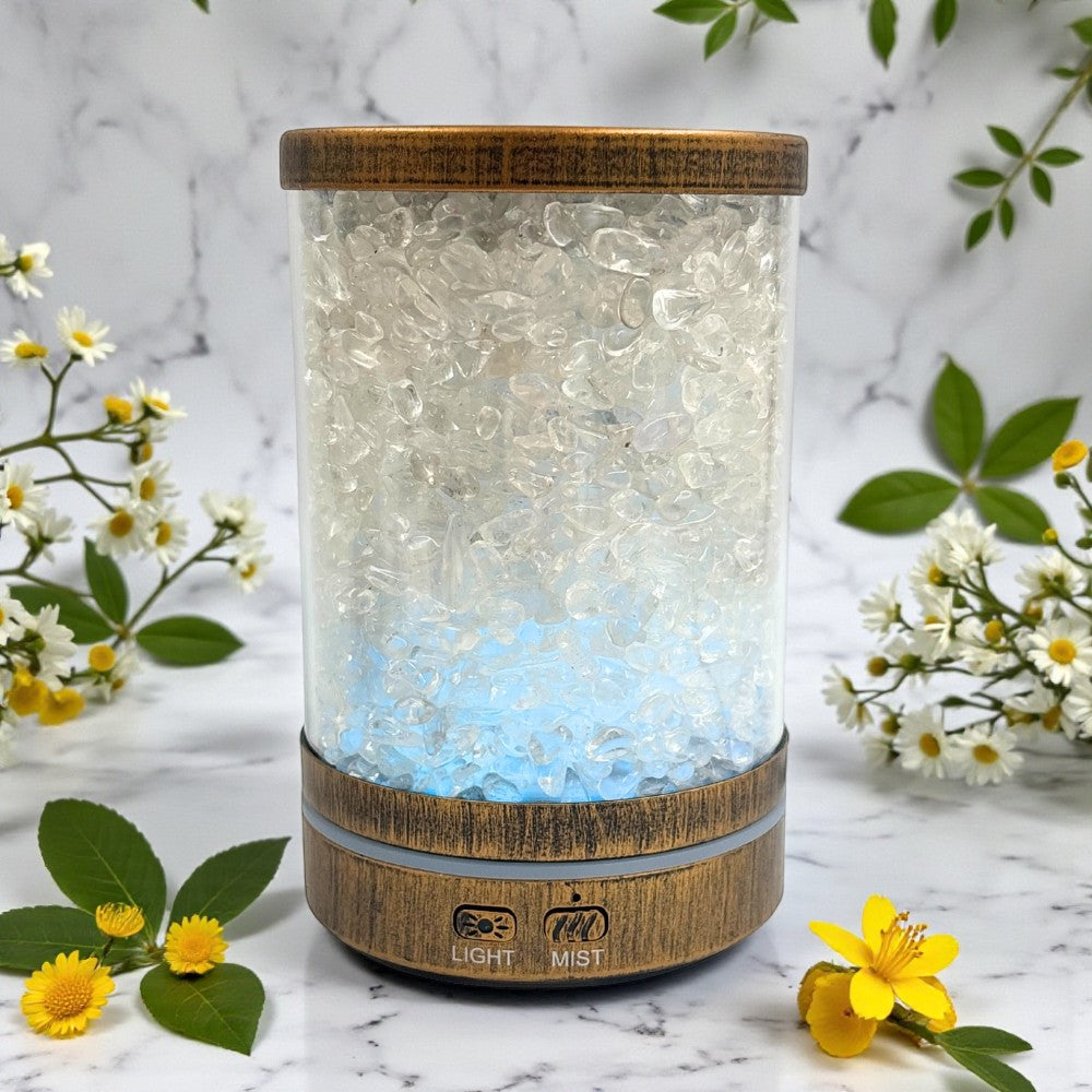 A diffuser with wooden top and base on a marble surface with flowers around