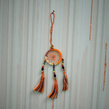 Dreamcatcher with orange and black tassels on a striped background