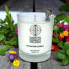 Candle labeled 'Earth's Elements Wellness' with flowers and greenery in the background