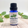 Bottle of French Basil essential oil with basil leaves in the background