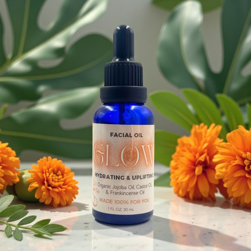 Facial oil bottle labeled 'GLOW' with marigold flowers and green leaves in the background