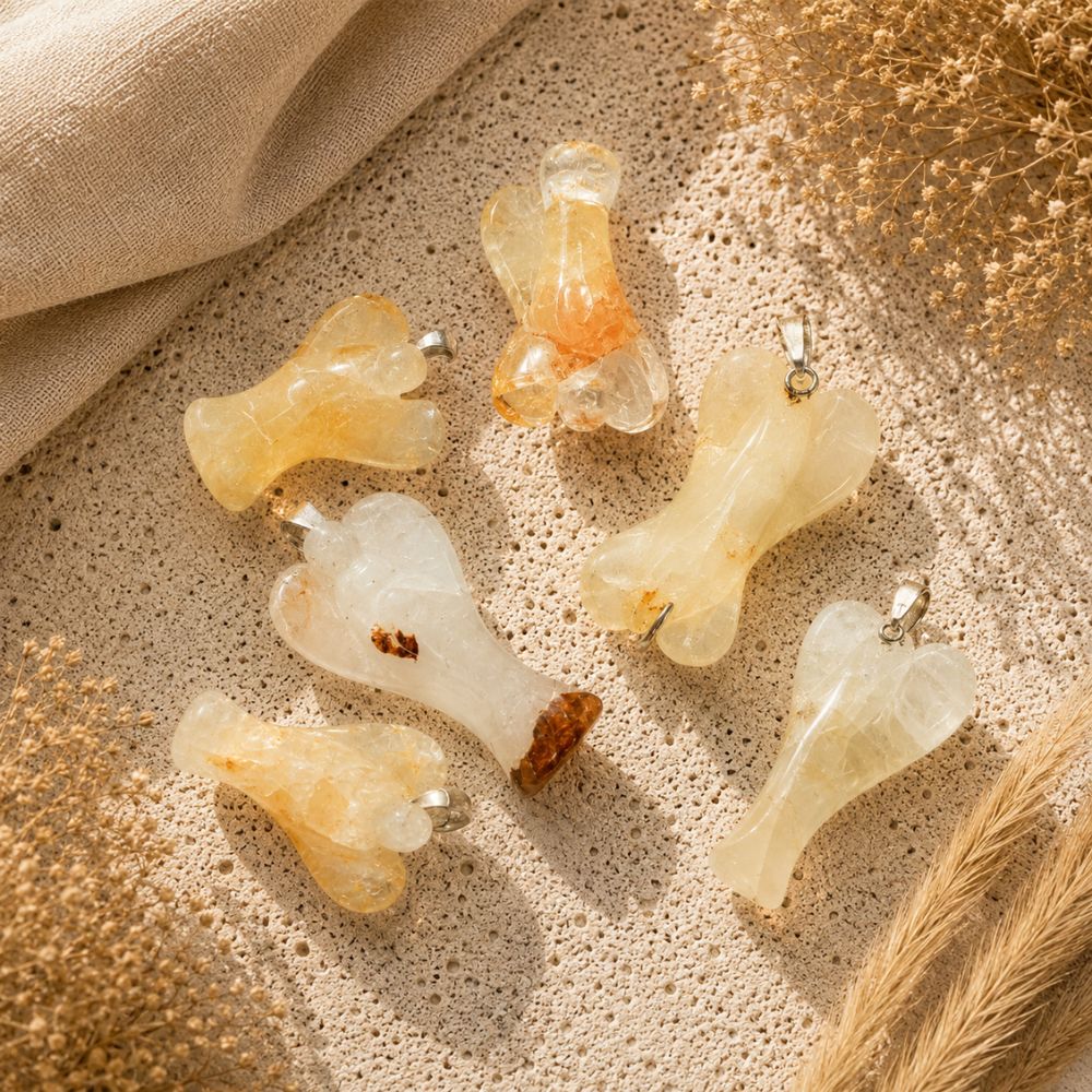 Golden Healer Angel Pendants displayed on a neutral stone background with soft linen and dried botanicals.