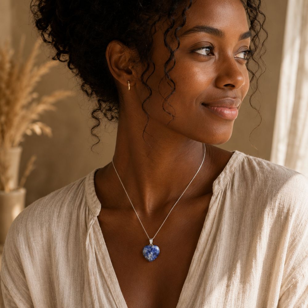 Woman wearing a Sodalite heart pendant necklace with a casual neutral outfit. 