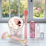 Cosmetic set with a candle, brush, roller, and other items on a surface with a window in the background.