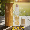 Earth's Elements Wellness Infinite Abundance essential oil roll-on bottle and packaging on a wooden surface with flowers.