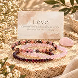 Three beaded stretch bracelets displayed on a textured stone slab with a pink crystal and a card reading 'Love' from Earths Energetics.