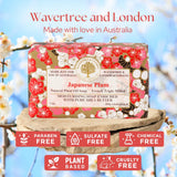 A boxed bar of soap from Wavertree and London, labeled Japanese Plum, displayed on a stone pedestal with a blurred blue sky and white blossoms background. Text at the top reads 'Wavertree and London Made with love in Australia,' and six red badges at the bottom say paraben free, sulfate free, chemical free, plant based, and cruelty free.