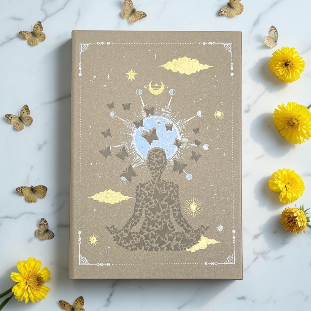Earths Elements Intention Journal on a marble surface with flowers and butterflies.