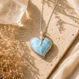Heart-shaped Larimar pendant on a chain against a natural background