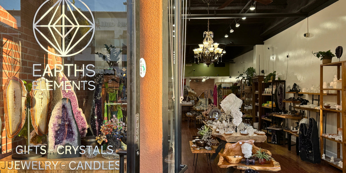 store front window with Earths Elements name and logo, and a view through the front door inside the store showing crystals and geodes ...