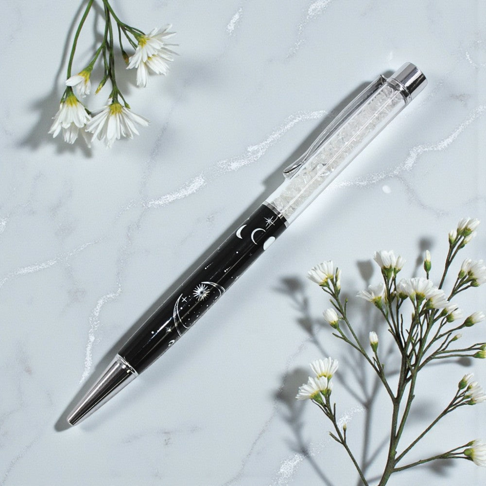 Pen with decorative elements on a light gray surface with white flowers