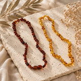 Natural amber baby teething necklaces in honey and cognac amber with polished round beads.