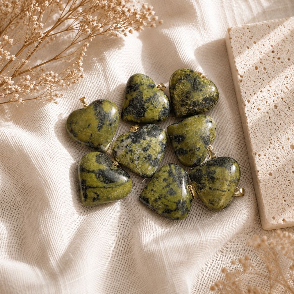 Olive Serpentine mini heart pendants displayed on a natural stone surface