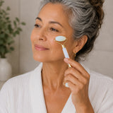 Woman using a facial roller on her face in a home setting