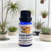 Bottle of Palo Santo oil blend with plants in the background